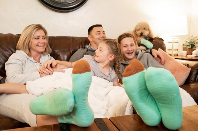 family sitting on couch, colorful socks in the foreground