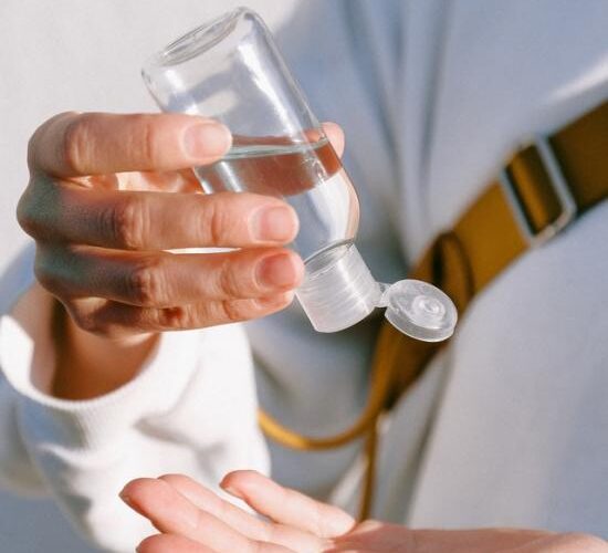 person-in-white-long-sleeve-shirt-holding-clear-bottle-3962516